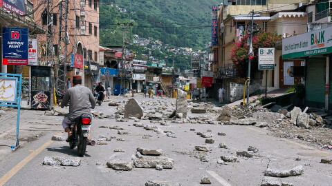Motorcyclists navigate through a road barricaded with concrete blocks set up by supporters of the outlawed Joint Awami Action Committee (JAAC) during a protest demanding greater political rights and the abolition of 12 legislative refugee seats, in Muzaffarabad, the capital of Pakistan-administered Kashmir, Saturday, Aug. 1, 2026.