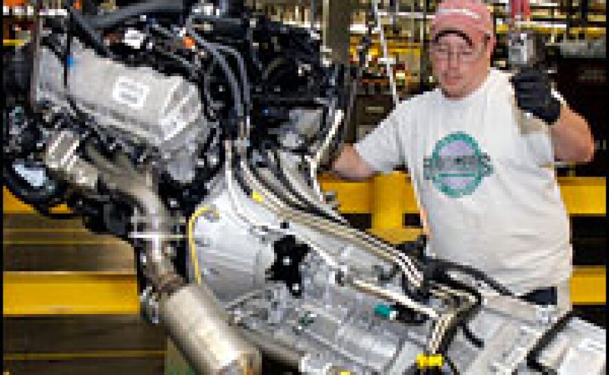 An assembly-line worker installs an engine into a new Ford F-150 truck at a plant in Dearborn, Mich., in October.