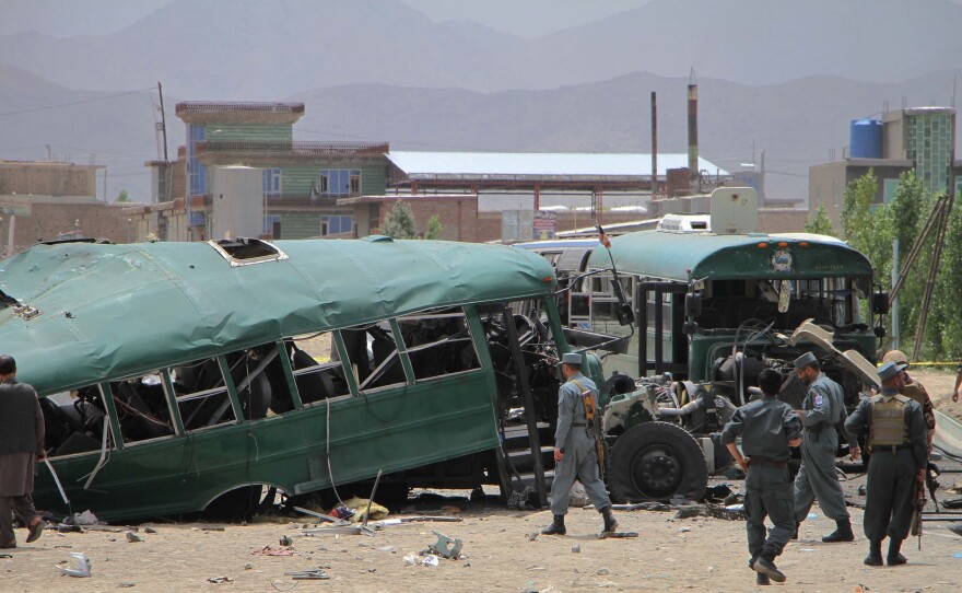Afghan police inspect the site in in Kabul, Afghanistan, where a bus convoy was attacked on Thursday. The buses carrying police cadets were targeted as they were on their way from the neighboring Maidan Wardak province to Kabul.