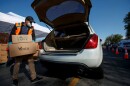 Anthony Torres loads a vehicle with food at the Los Angeles Regional Food Bank at Franklin D. Roosevelt Park in Los Angeles on March 23, 2021. 