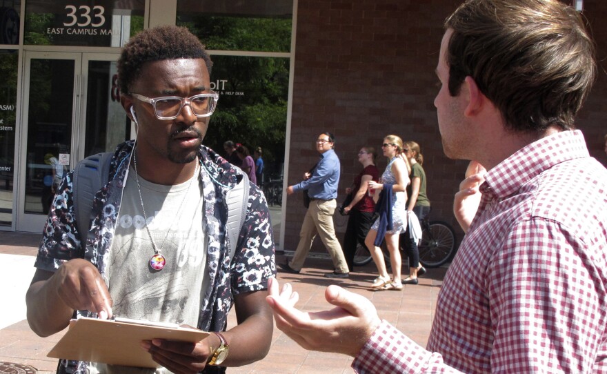 A University of Wisconsin student gets information about registering to vote from a NextGen America worker in Madison, Wis., in 2018.