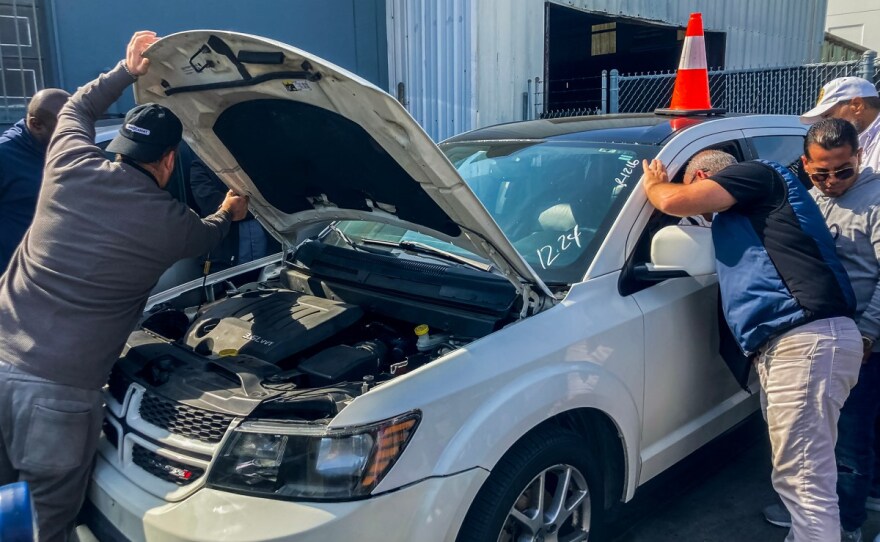 Gente inspecciona un vehículo en una subasta en Bruffy's Tow en Marina Del Rey el 18 de febrero de 2025.