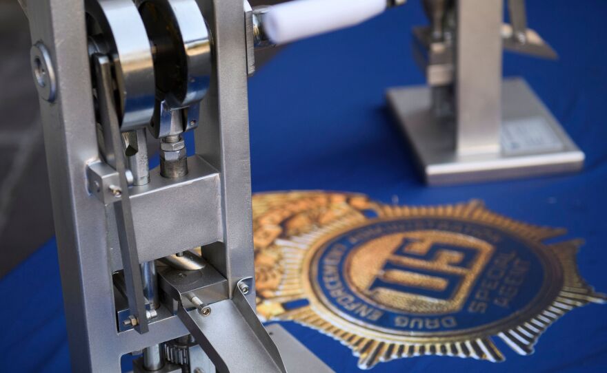 A pill press machine seized by authorities is displayed during a news conference outside the Roybal Federal Building in February 2021 in Los Angeles.