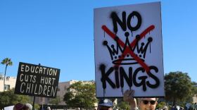 Protesters hold up signs during a demonstration for a 'No Kings' rally in San Diego on Oct. 18, 2025. 
