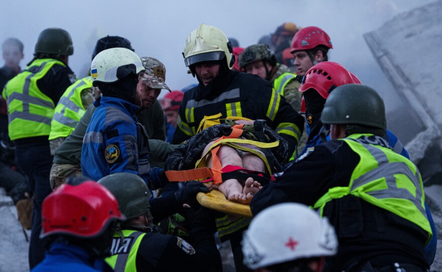 Rescue workers carry an injured woman on a stretcher from a house heavily damaged after a Russian strike on a residential neighborhood in Kyiv, Ukraine, on Thursday, May 14, 2026.