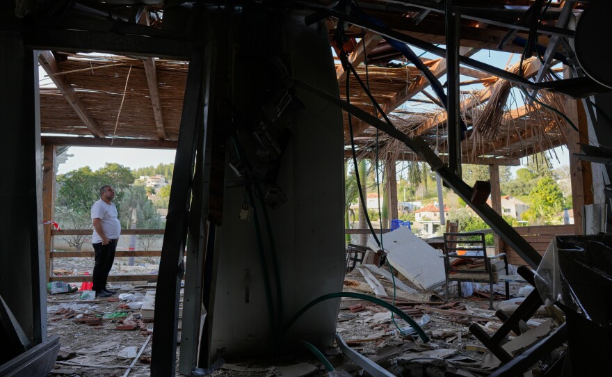 Residents inspect their home after it was struck by an Iranian missile in Eshtaol, central Israel, Saturday, March 28, 2026.