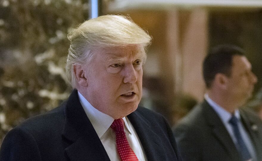 President-elect Donald Trump speaks to members of the media in the lobby at Trump Tower on Tuesday after transition officials announced Trump has sold all of his stock holdings.