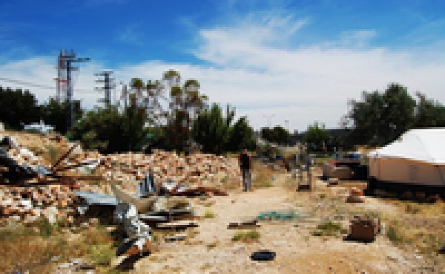 Odeh Abu Tarbush walks between the house destroyed by Israel that his extended family had been renting from the Latin Patriarchate, Jerusalem's main Catholic diocese, and the tents aid groups gave as a replacement. The local church is preparing a lawsuit against Israeli government claims that there had been construction on the property without a permit.