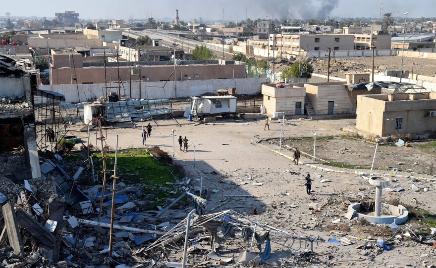 Iraqi soldiers walk inside a government complex recaptured from ISIS fighters in central Ramadi, Iraq, Monday.