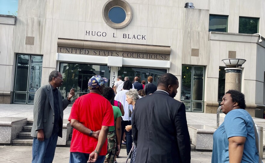 A line of people wait outside the federal courthouse in Birmingham, Ala., on Aug. 14 for a hearing to consider new congressional districts. Federal judges had ruled that the state's 2022 district map diluted Black voters' power.