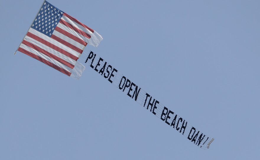 Florida Gov. Ron DeSantis Santis allowed beaches to reopen on April 17, but some officials around the state aren't following his lead. A banner plane flies a sign on April 19 urging Miami Beach Mayor Dan Gelber to open the beaches. Gelber has said the beaches there are unlikely to reopen before June.