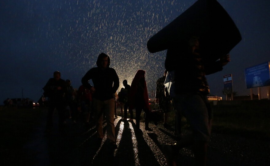 Migrants arrive during heavy rain at the Hungarian-Austrian border in Nickelsdorf, Austria, early Saturday.