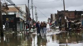 People look at homes and businesses destroyed during Superstorm Sandy on Tuesday in the Rockaway section of Queens, N.Y.