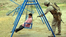A U.S. Marine pushes a child on a swing in southern Afghanistan on March 4. After a decade of nation-building in Afghanistan, and nearly as long in Iraq, the U.S. appears to be losing it appetite for such efforts.