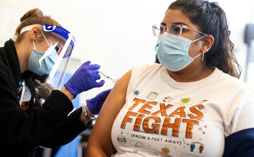 Medical assistant Esmeralda Torres receives the Pfizer-BioNTech COVID-19 vaccine during injections to health care workers at Dell Medical School at the University of Texas at Austin on Dec. 15.