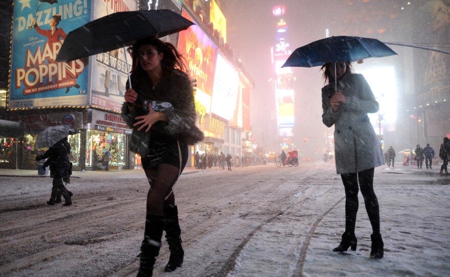 Two women look for a taxi in New York's Times Square on Friday.