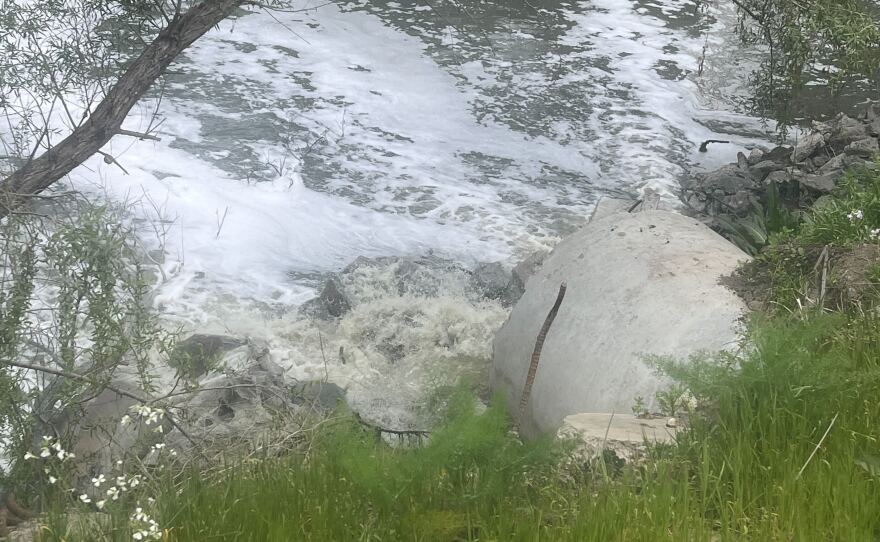 Wastewater flows out of pipe and polluted foam clouds float on top of the Tijuana River in the Nestor neighborhood of San Diego, California on April 16, 2025.