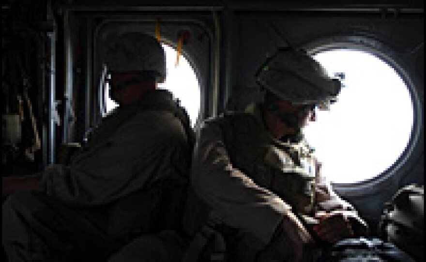 Members of the 24th Marine Expeditionary Unit fly across the southern Afghanistan desert in a helicopter.