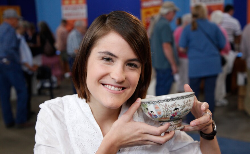 A guest displays her Chinese enameled porcelain bowl, ca. 1920.