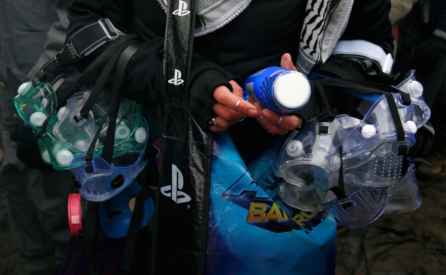 A protester gathers goggles and Milk of Magnesia in anticipation of a confrontation and tear gas as she prepares to cross to the island. No clashes occurred.