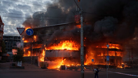 A man carries a box from a burning trade center after a Russian strike on Kyiv, Ukraine, on Sunday, May 24, 2026.
