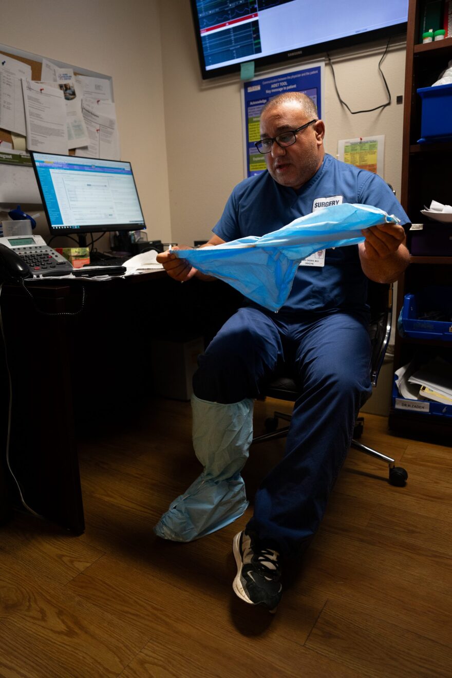 Dr. Hamid Zadeh puts on his PPE on his way to perform a caesarian section at Pioneers Memorial Hospital on Aug. 8, 2024. 