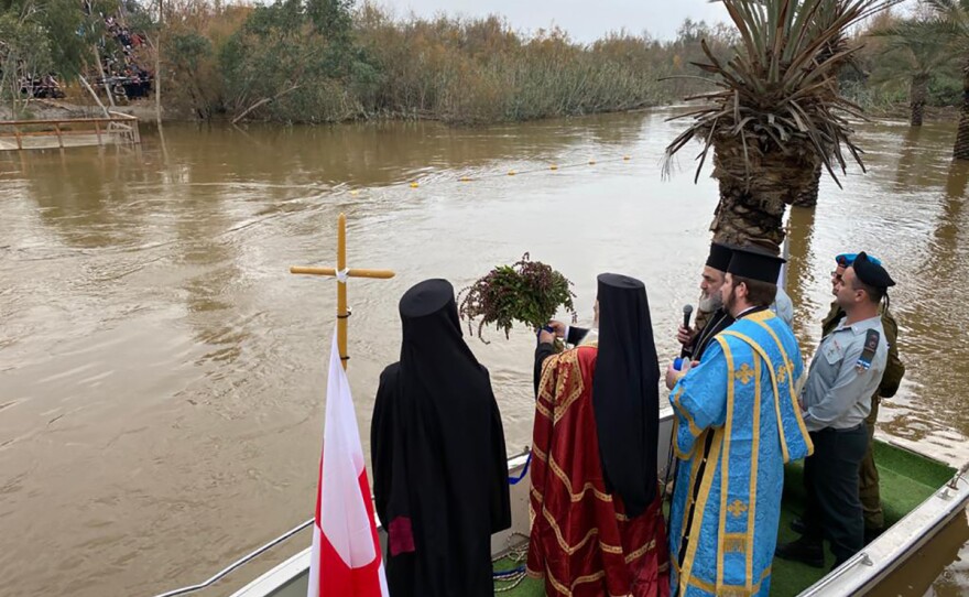 Orthodox Church Patriarch of Jerusalem Theophilos III tosses a bouquet of basil into the Jordan River, at Qasr al-Yahud, a baptism site near the West Bank city of Jericho, on Jan. 18. Basil is believed to have grown near the cross where Jesus was crucified and is used for blessings.