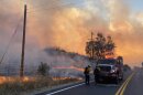 Two firefighters checking their gears as the Border 32 Fire rages near them, Aug. 31, 2022.