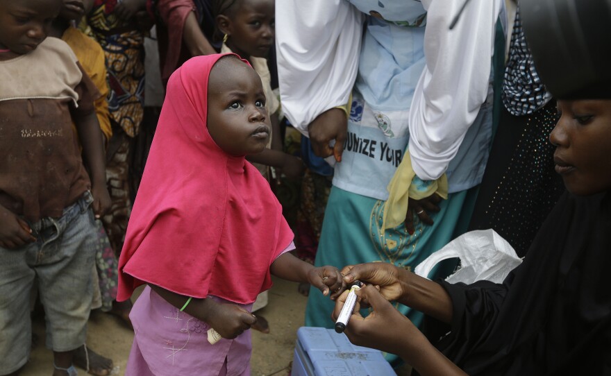 Photo taken Sun., Aug. 28, 2016. A health official inks a child finger to indicate she has been administered with a polio vaccine at a camp of people displaced by Islamist extremist in Maiduguri, Nigeria.