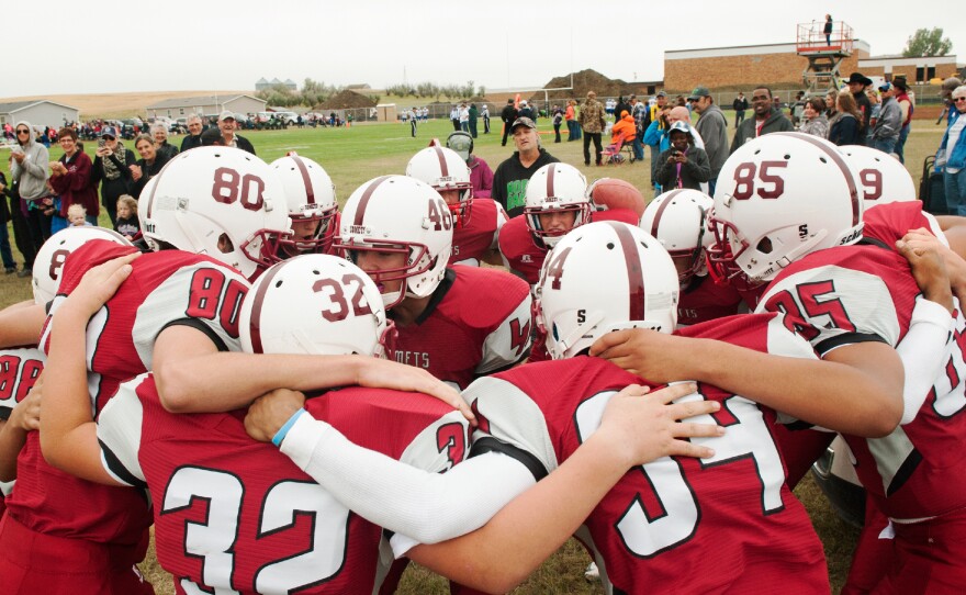 The Alexander Comets huddle and chant before taking the field for the first time since 1987.