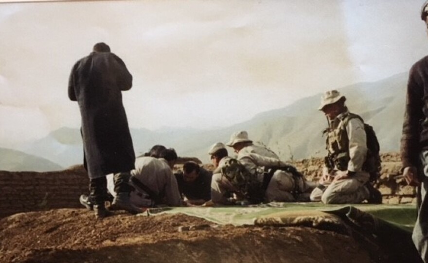 U.S. troops, in tan uniforms, look over maps with Afghan rebel commander Rashid Dostum (center) in October 2001. A dozen U.S. soldiers teamed up with Dostum's force to defeat the Taliban in northern Afghanistan.