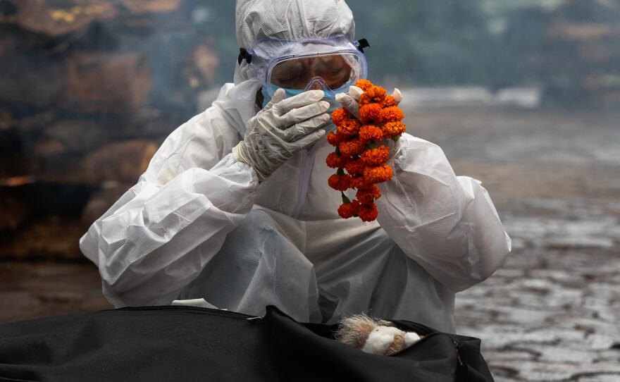 Performing last rites before the cremation of a family member who died of COVID-19.