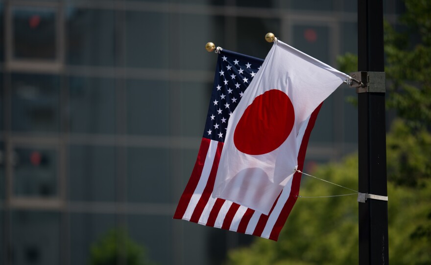 A Japanese and a U.S. flag are seen next to the Hiroshima Peace Memorial in Hiroshima on Friday.