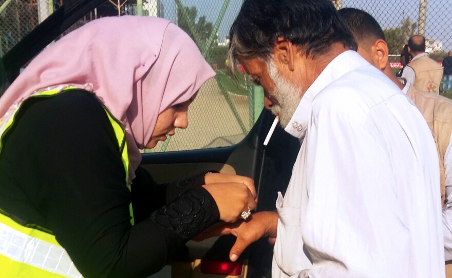 Hanan Abu Qassem (left) treats Kamal Bahoum (right), a soccer fan injured during scuffles at the gate to Gaza's main soccer stadium. The presence of female EMTs at the soccer games has stirred controversy, and Abu Qassem has been warned she may be barred from future games.