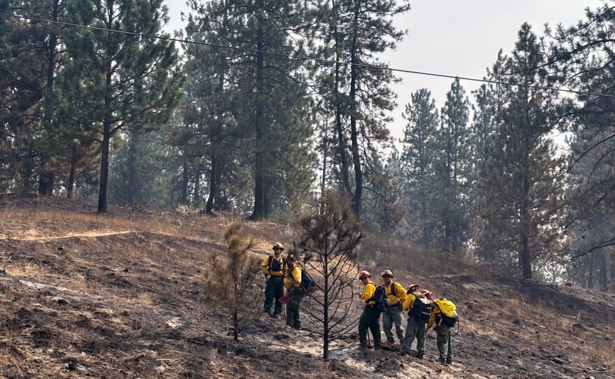 Firefighters work to douse hot spots on the Old Trails Fire on Tuesday.