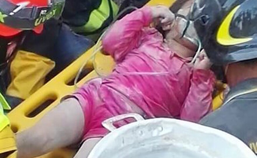Italian firefighters pull out Giorgia Rinaldo from under the rubble of the town of Pescara del Tronto, central Italy, on Wednesday.