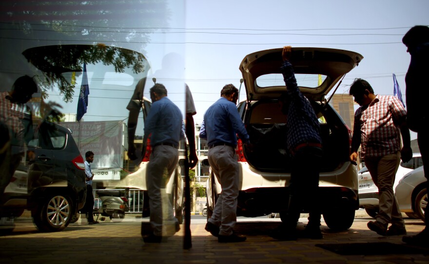 A salesman walks past an SUV for sale at a car dealership in New Delhi. Some residents there are buying a second car with either odd or even license plate numbers so they can beat the government's car rationing system to cut down on traffic and air pollution.