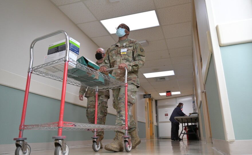 Sgt. Darrin Cushard (L) and Sgt. Dennis McClarity (R) walk with a cart of PPE supplies in St. Claire Regional Medical Center on September 16, 2021 in Morehead, Kentucky.