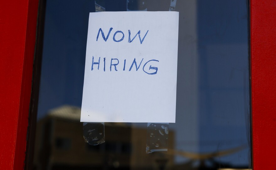 A "Now Hiring" sign is displayed on a storefront in the Adams Morgan heighborhood in Washington, D.C., on Oct. 07, 2022 .