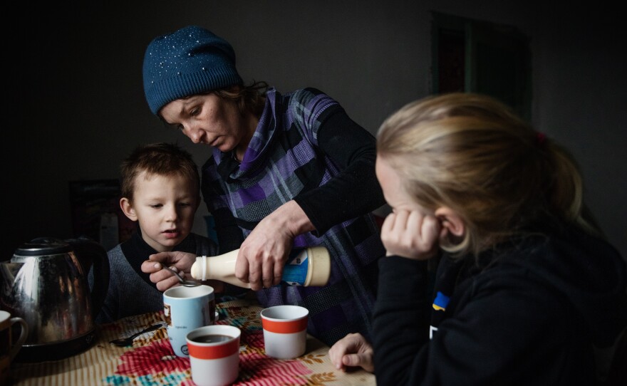 Olga Grinik with her son Kirill, 5, and daughter Miroslava, 8, in the kitchen of their new house in Poltava region. December 2022.