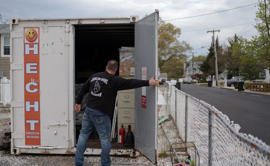 Doug Quinn closes his storage container, on the empty lot of his home destroyed by Superstorm Sandy.