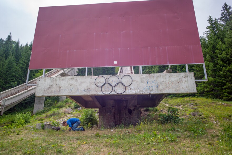 A man prays during Ramadan beneath handmade Olympic rings on one of the former ski jumps in Sarajevo, where the 1984 Winter Games were held.