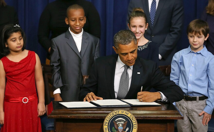President Obama signs a series of executive orders on gun control Jan. 16 surrounded by children who wrote letters to the White House about gun violence. They are, from left, Hinna Zeejah, Taejah Goode, Julia Stokes and Grant Fritz.