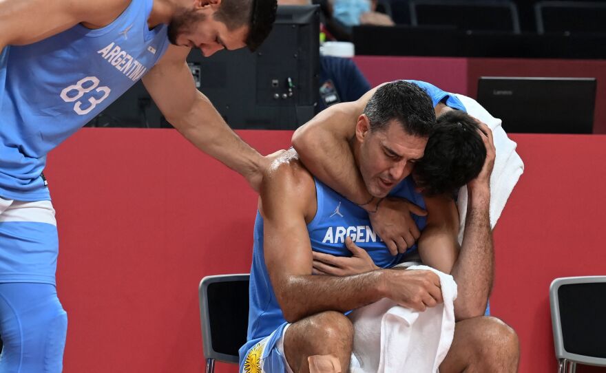 Argentina's Luis Scola, center, is comforted by teammates at the end of the men's quarter-final basketball match between Australia and Argentina on August 3. Scola is retiring from Argentina's national team after the Tokyo Olympics.
