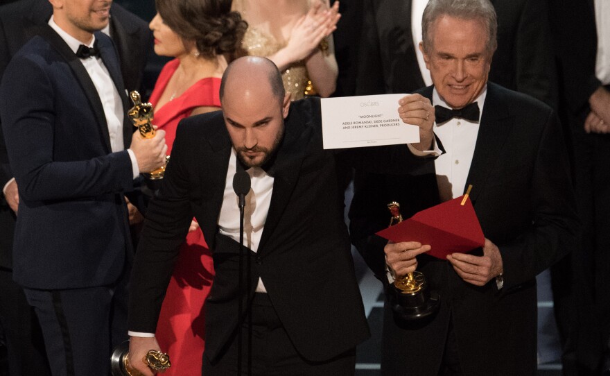 Envelope-gate: "La La Land" producer Jordan Horowitz holds up the card with the correct winner, "Moonlight," as presenter Warren Beatty looks on.