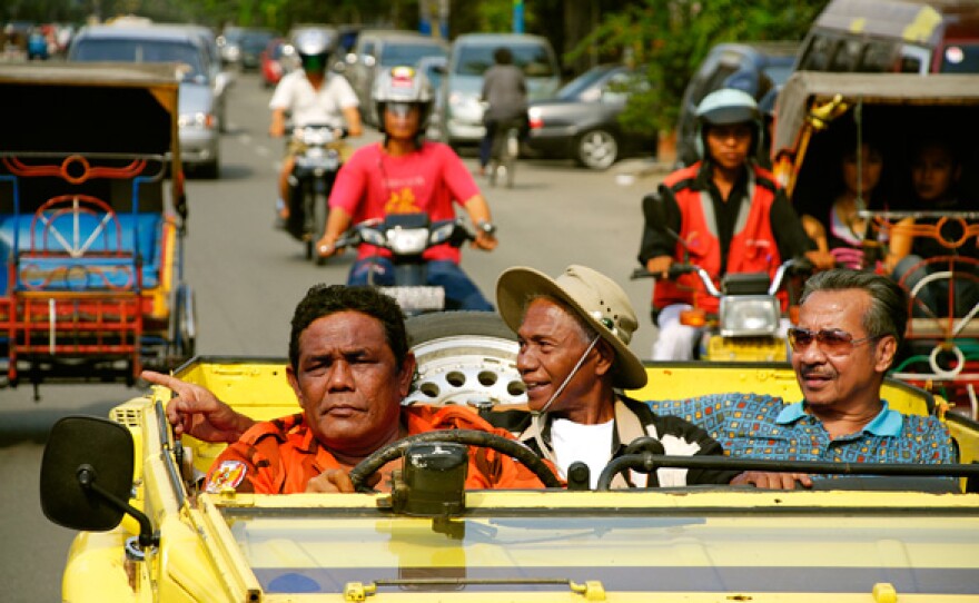 Anwar Congo driving a car. When the government of Indonesia was overthrown by the military in 1965, Congo and his friends were promoted from small-time gangsters ("free men," as they called themselves) who controlled the black market in movie tickets to death squad leaders. They helped the army kill more than one million alleged communists, ethnic Chinese and intellectuals in less than a year.