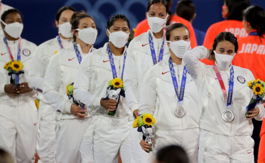 U.S. softball players wear their masks after collecting their silver medals.