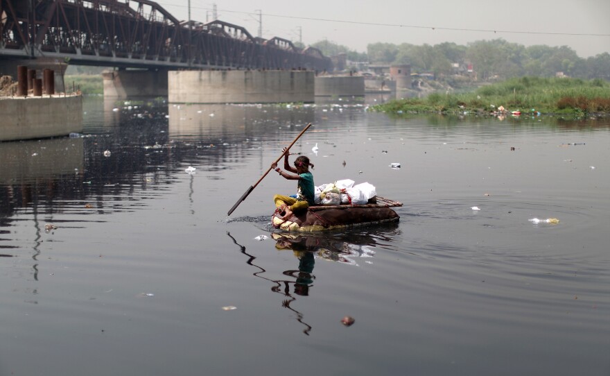 Children scavenge the garbage-strewn banks of the Yamuna River, diving into the black water for coins and small religious figures.