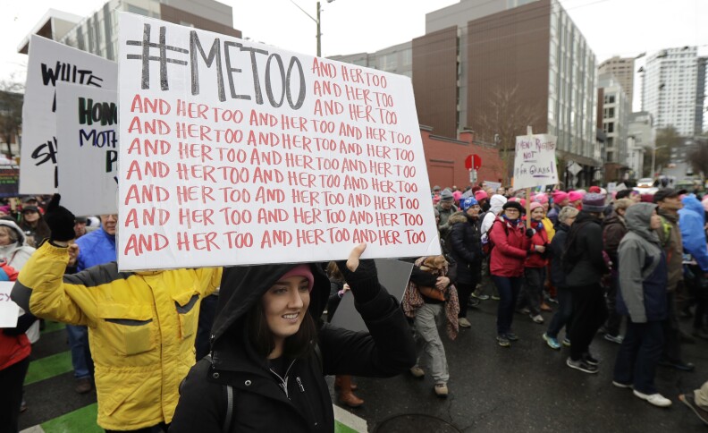 A marcher carries a sign with the popular Twitter hashtag #MeToo used by people speaking out against sexual harassment as she takes part in a Women's March in Seattle, Saturday, Jan. 20, 2018. 