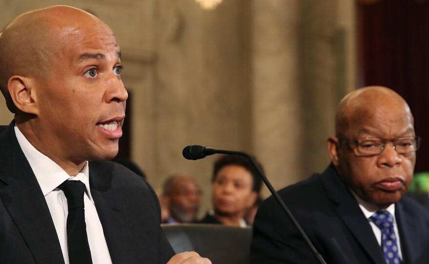 Sen. Cory Booker (left) reads a statement speaking out against Attorney General nominee Jeff Sessions during a Senate Judiciary Committee hearing on Wednesday. Sitting with Booker is Rep. John Lewis.